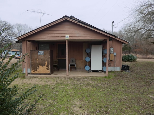 back of property with a yard and a patio