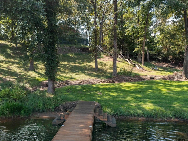 view of dock featuring a yard and a water view