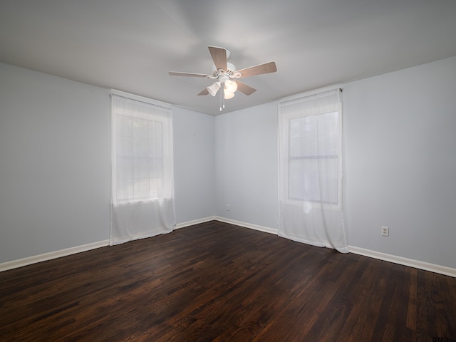 spare room with dark hardwood / wood-style flooring and ceiling fan