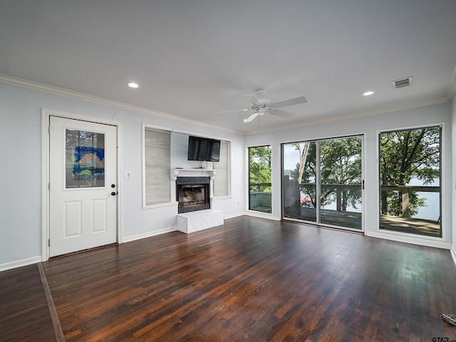 unfurnished living room featuring ornamental molding, dark wood-type flooring, ceiling fan, and a tile fireplace