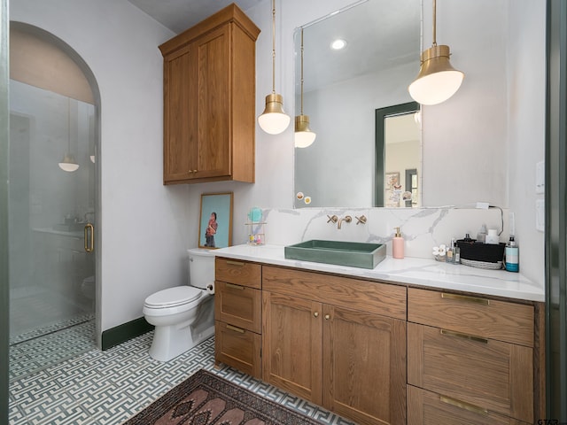 bathroom with backsplash, toilet, a shower stall, vanity, and tile patterned floors