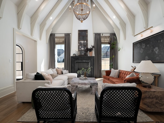 living room with beam ceiling, plenty of natural light, and wood finished floors