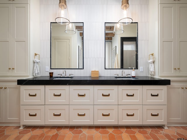 full bath with double vanity, tile patterned flooring, and a sink