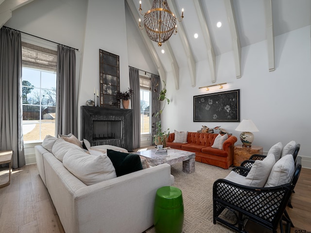 living room with a fireplace, an inviting chandelier, wood finished floors, high vaulted ceiling, and beamed ceiling