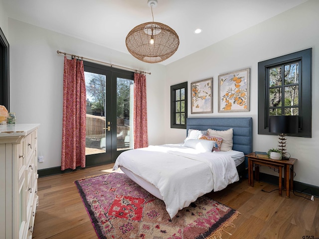 bedroom with light wood finished floors, baseboards, access to exterior, french doors, and recessed lighting