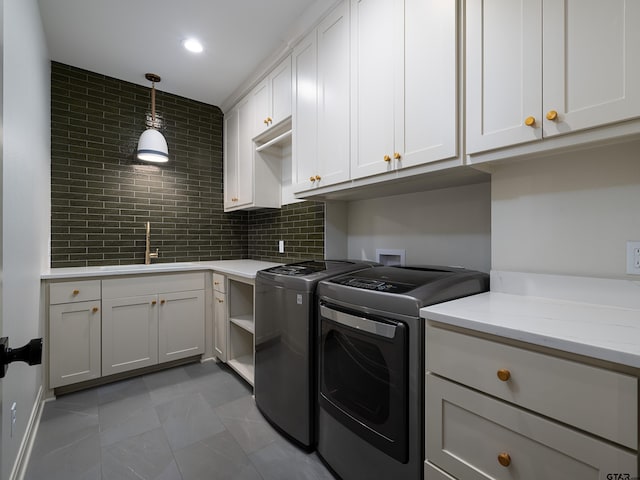 laundry room featuring recessed lighting, cabinet space, a sink, and separate washer and dryer