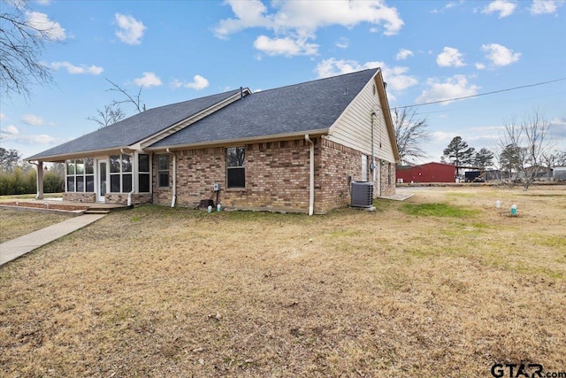 rear view of property with cooling unit and a yard