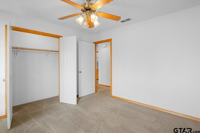 unfurnished bedroom featuring light carpet, a closet, and ceiling fan