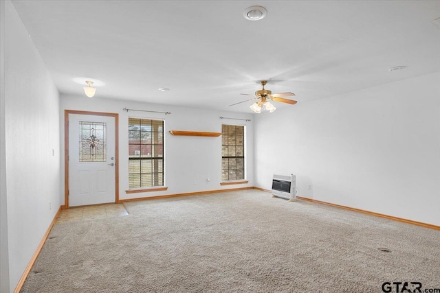 unfurnished living room with heating unit, light carpet, and ceiling fan