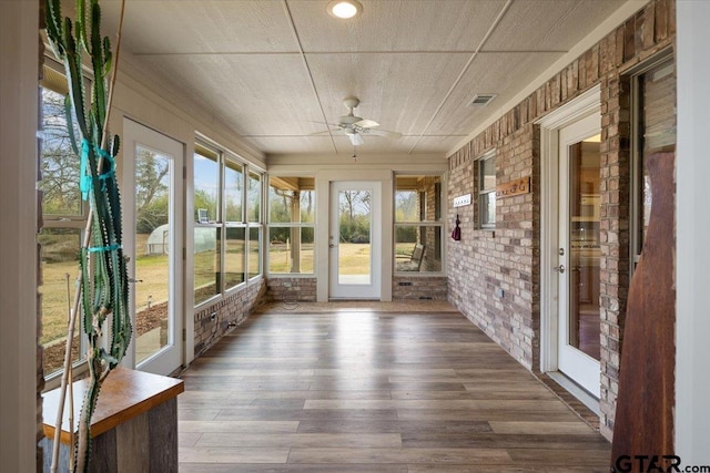 unfurnished sunroom featuring ceiling fan