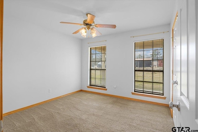 carpeted spare room featuring ceiling fan