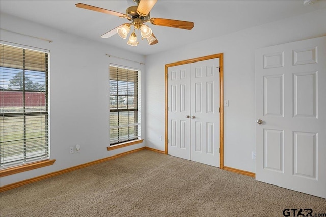 unfurnished bedroom with ceiling fan, a closet, and carpet