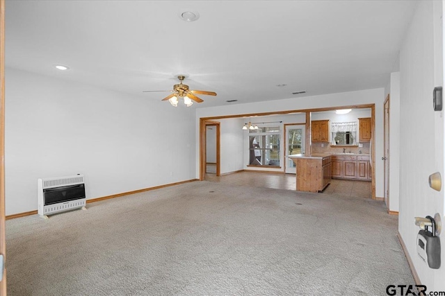 unfurnished living room featuring ceiling fan, light carpet, and heating unit