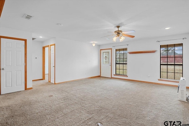 spare room with light colored carpet and ceiling fan