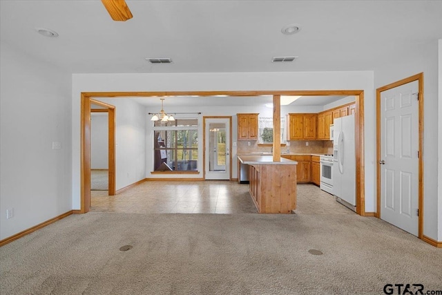 kitchen with white appliances, backsplash, a center island, light carpet, and decorative light fixtures