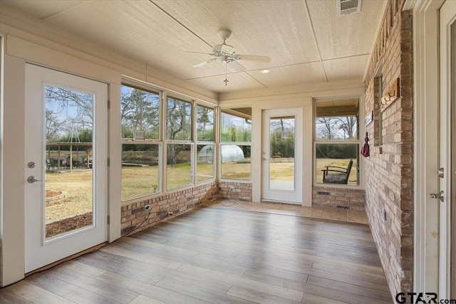 unfurnished sunroom featuring a wealth of natural light and ceiling fan