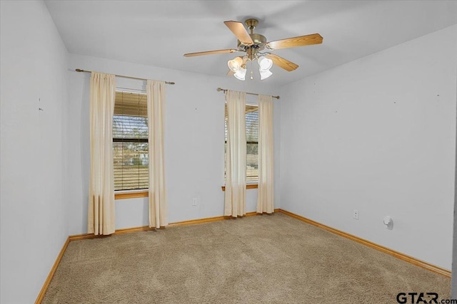 carpeted empty room with a wealth of natural light and ceiling fan