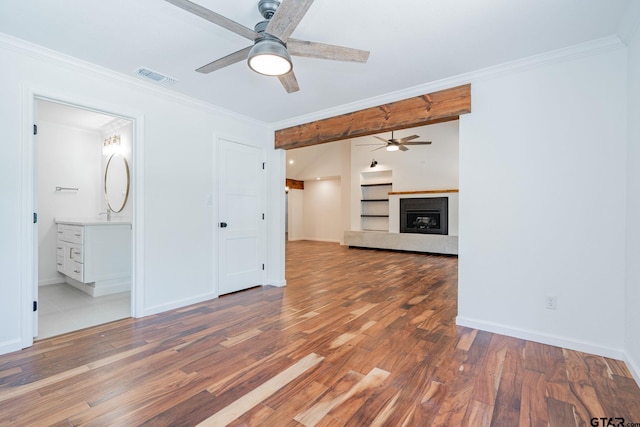 unfurnished living room featuring hardwood / wood-style flooring, built in features, ornamental molding, and ceiling fan