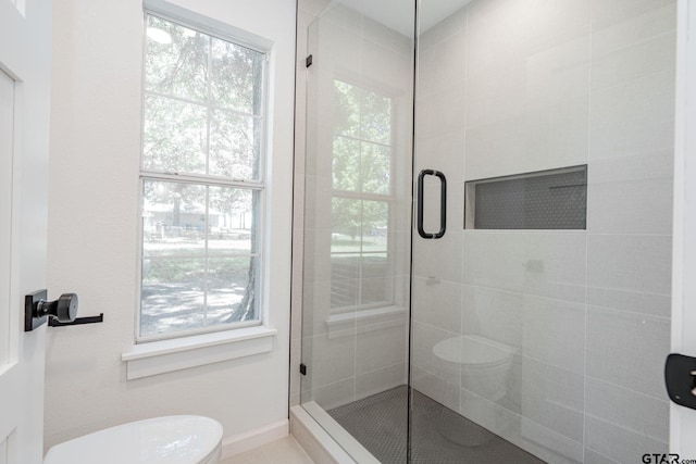 bathroom with toilet, walk in shower, and plenty of natural light