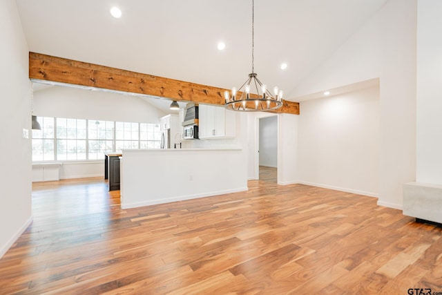 unfurnished living room featuring high vaulted ceiling, an inviting chandelier, beamed ceiling, and light wood-type flooring