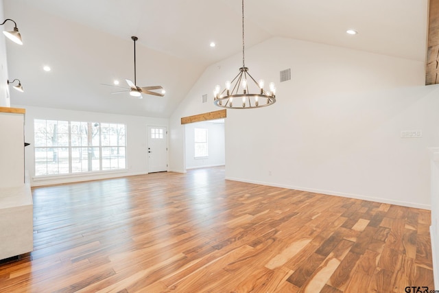 unfurnished room featuring ceiling fan with notable chandelier, light hardwood / wood-style flooring, and high vaulted ceiling