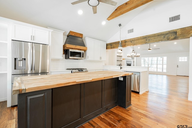 kitchen with white cabinets, decorative light fixtures, backsplash, kitchen peninsula, and beam ceiling