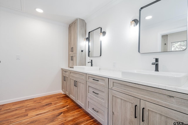 bathroom with wood-type flooring, crown molding, and vanity