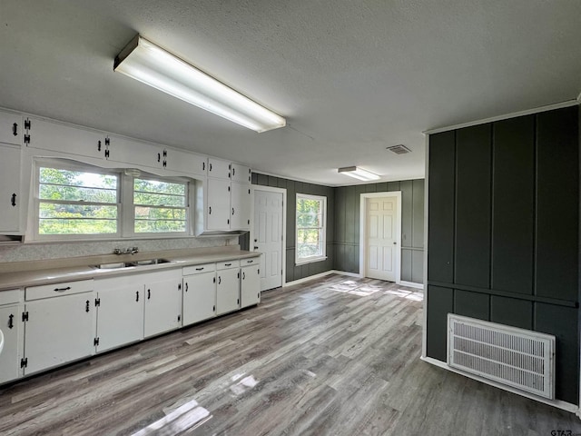 1725 S Mahon Ave, Tyler, TX 75701 - kitchen featuring white cabinetry, light countertops, light wood-type flooring, and a textured ceiling