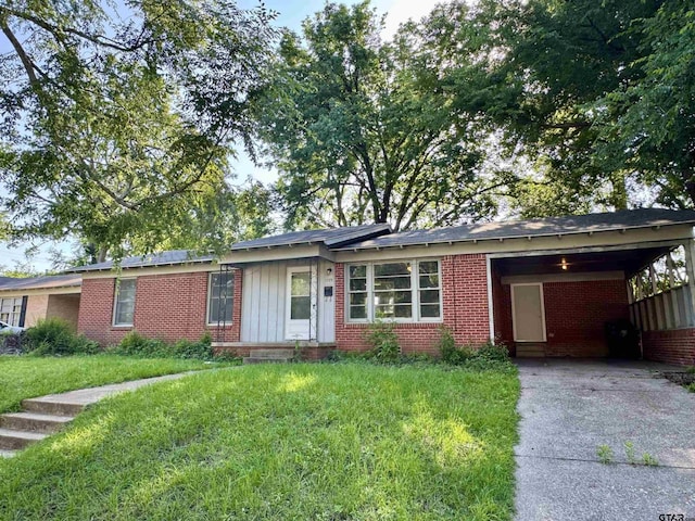 1725 S Mahon Ave, Tyler, TX 75701 - ranch-style house with brick siding, concrete driveway, a carport, a front lawn, and board and batten siding