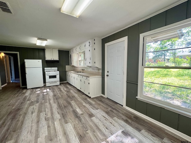1725 S Mahon Ave, Tyler, TX 75701 - kitchen featuring white appliances, a decorative wall, white cabinetry, light wood finished floors, and light countertops