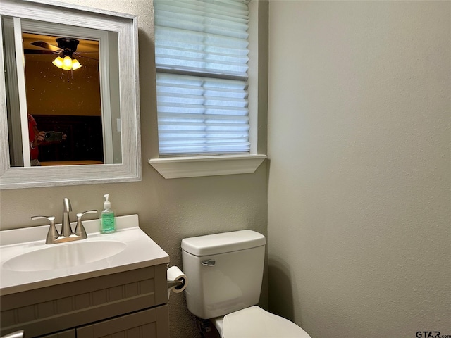 bathroom with vanity, toilet, and ceiling fan