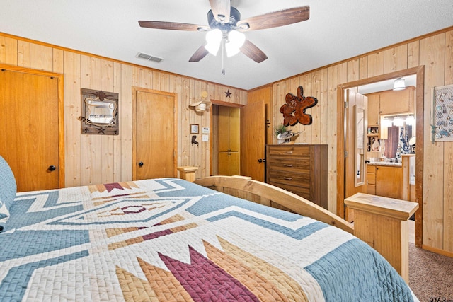 10929 County Road 41, Tyler, TX 75706 - carpeted bedroom featuring wooden walls, crown molding, and a ceiling fan