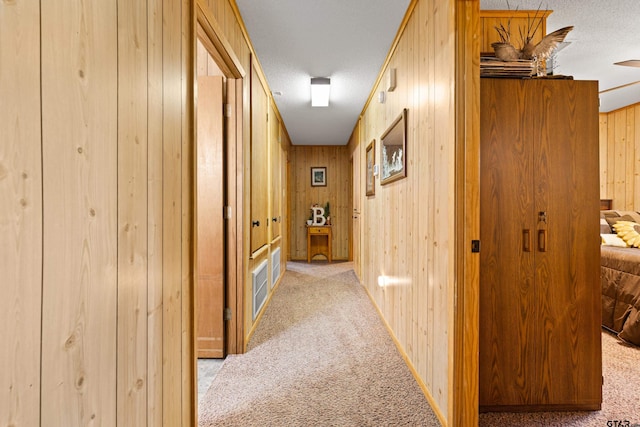 10929 County Road 41, Tyler, TX 75706 - hallway with light carpet, wooden walls, and a textured ceiling