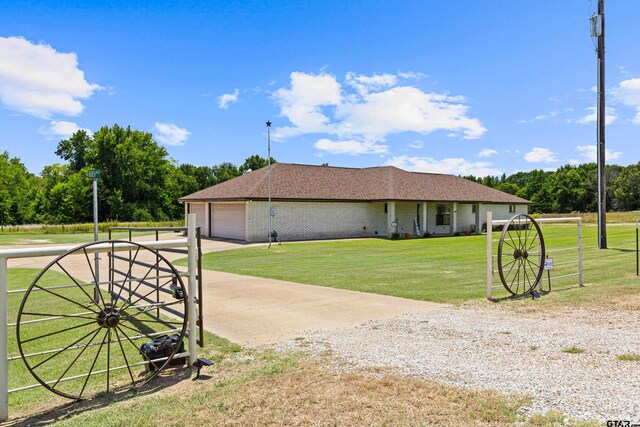 10929 County Road 41, Tyler, TX 75706 - view of home's exterior with concrete driveway, a garage, brick siding, and roof with shingles