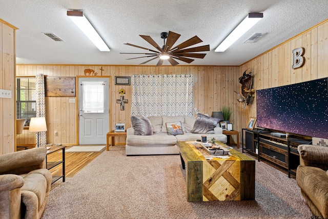 10929 County Road 41, Tyler, TX 75706 - living room featuring wood walls, a textured ceiling, ceiling fan, wood finished floors, and ornamental molding