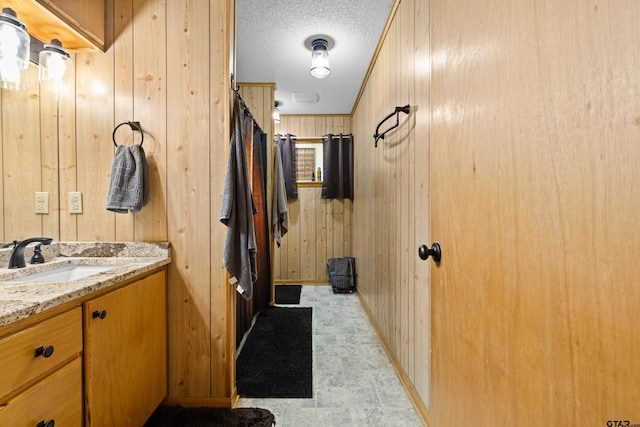 10929 County Road 41, Tyler, TX 75706 - bathroom with wooden walls, vanity, and a textured ceiling