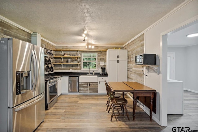 3268 Farm Rd Unit 1487, Bogata, TX 75417 - kitchen featuring appliances with stainless steel finishes, open shelves, ornamental molding, light wood-type flooring, and white cabinetry