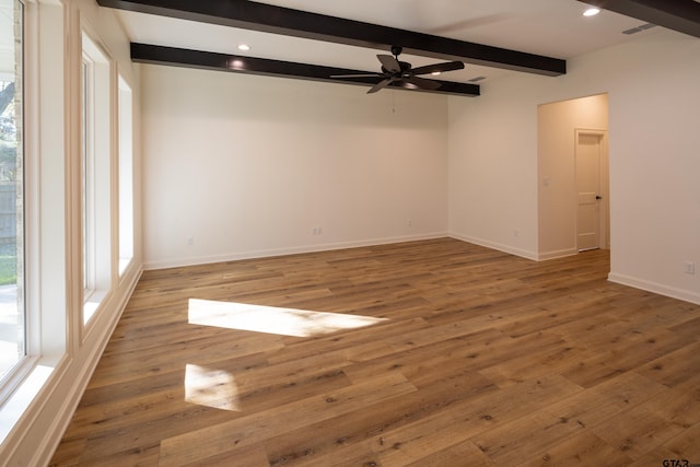 empty room with hardwood / wood-style floors, ceiling fan, and beam ceiling