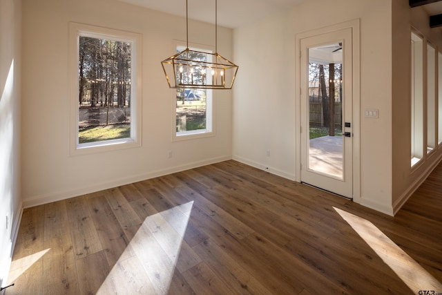 unfurnished dining area featuring dark hardwood / wood-style floors and a notable chandelier