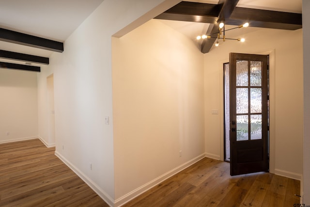 entrance foyer with dark hardwood / wood-style floors, beam ceiling, and an inviting chandelier