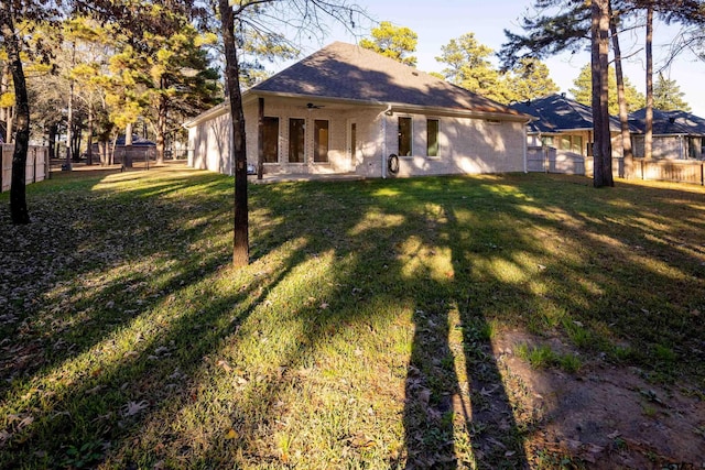 exterior space with ceiling fan and a yard