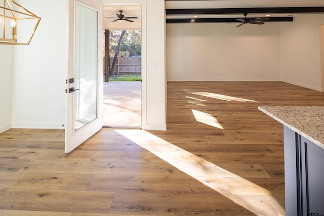 interior space featuring beamed ceiling, french doors, light wood-type flooring, and ceiling fan