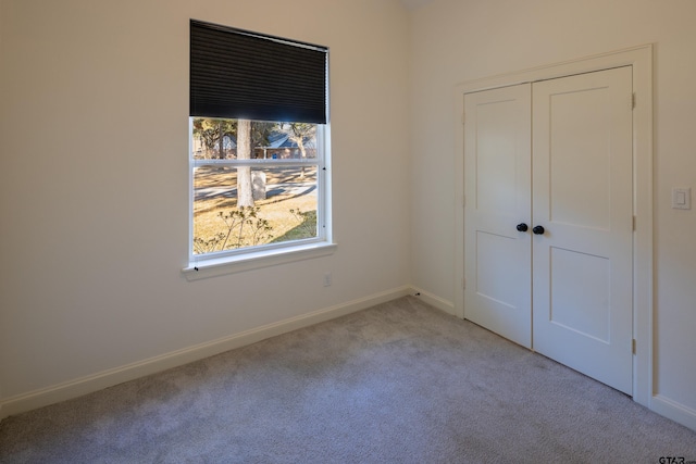 unfurnished bedroom featuring light carpet and a closet