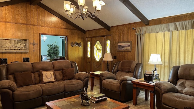 living room featuring lofted ceiling with beams, hardwood / wood-style floors, a notable chandelier, and wooden walls