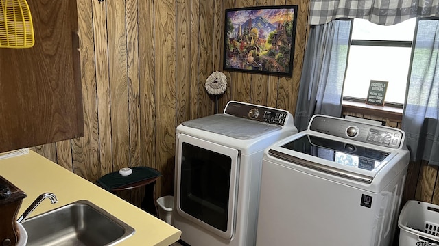 washroom featuring washer and dryer and wooden walls