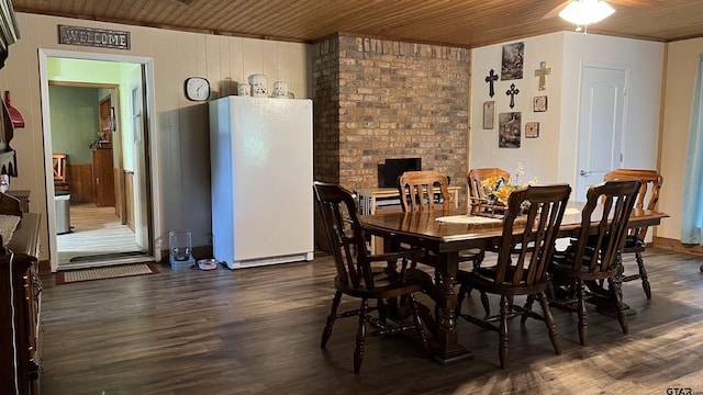 dining room featuring dark wood-type flooring, wooden ceiling, and ceiling fan