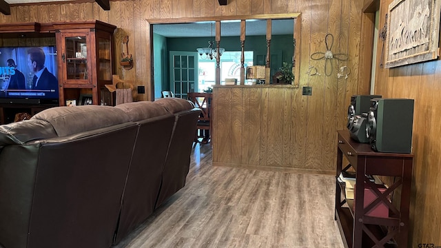 living room featuring hardwood / wood-style floors, an inviting chandelier, and wood walls