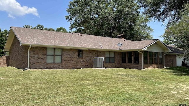 rear view of house featuring a yard and central AC