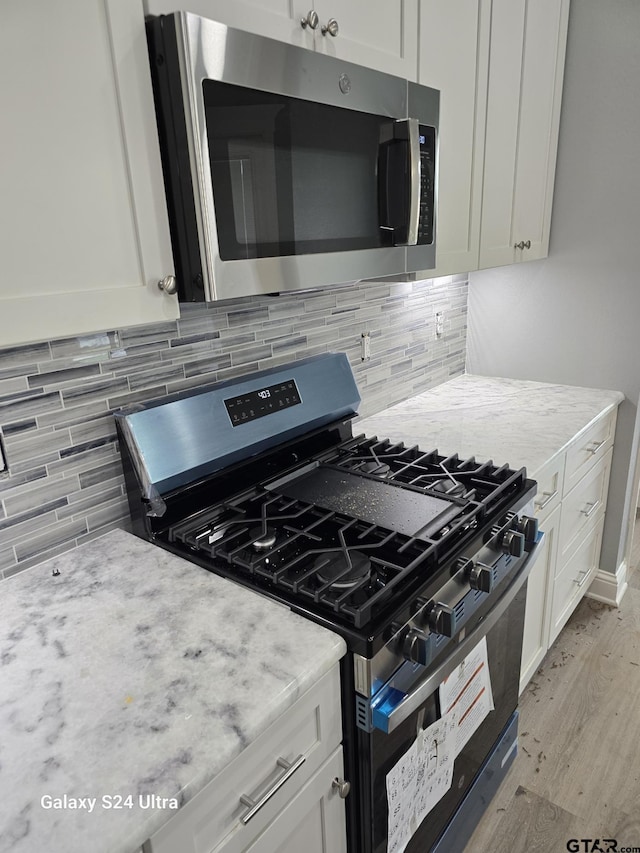 913 Alex Dr, Whitehouse, TX 75791 - kitchen featuring stainless steel appliances, light wood finished floors, and white cabinetry