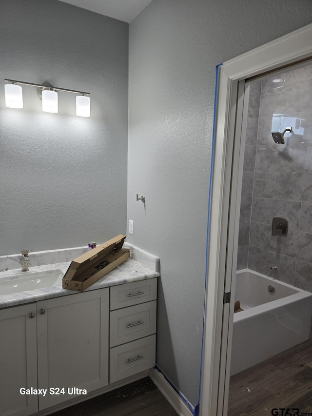 913 Alex Dr, Whitehouse, TX 75791 - bathroom featuring wood finished floors, vanity, and washtub / shower combination